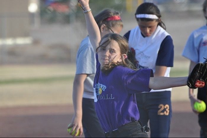 A 10-year-old Myka Sutherlin warms up before a Gilbert Little League Softball game.
